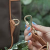 Antitheft water resistant Carmel Backpack with locking straps. Demonstration of the locking strap clasp on the brown-gold color Carmel.
