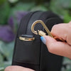 antitheft Crissy Mini Crossbody in black-gold with locking strap clasps. Secure your bag by using the strap clasps to deter pickpockets