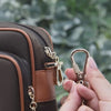 Anti-theft water resistant Crissy Full Crossbody. Demonstration of locking strap to secure bag