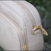 Anti-theft Water-resistant Verona Crossbody demonstrating water-resistant zippers with water droplets falling down the bag