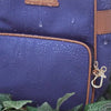 Anti-theft Water-resistant Carmel Backpack and Crossbody demonstrating water-resistance with water droplets falling down the bag